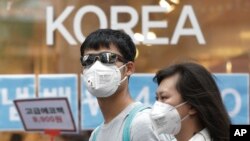 Un couple se protégeant contre le MERS en portant des masques (AP Photo/Ahn Young-joon)