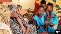 Une femme et des enfants assis avec d'autres personnes déplacées, Soudan le 12 septembre 2023. 