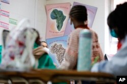Posters of traditional food sit on a classroom wall at the Kilombo Academic and Cultural Institute, March 28, 2023, in Decatur, Ga.