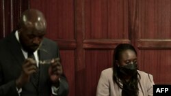 Dereva wa magari ya mashindano Maxine Wahome (kulia) na wakili wake Cliff Ombeta, wakiwa katika mahakama ya hakimu mkuu Nairobi, Januari 12, 2023. Picha na Tony KARUMBA / AFP.