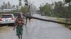 Une femme marche le long d'une rue endommagée par l'impact du cyclone Freddy dans la ville de Quelimane, au Mozambique, le 12 mars 2023
