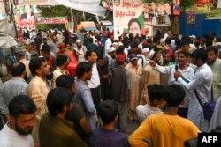Tehreek-e-Insaf (PTI) party activists and supporters gather outside Pakistan's former Prime Minister Imran Khan's residence to listen his speech, in Zaman Park in Lahore on May 13, 2023.