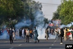 Pakistan Tehreek-e-Insaf (PTI) party activists and supporters of former Pakistan's Prime Minister Imran clash with police during a protest against the arrest of Former Pakistan prime minister Imran Khan, in Lahore on May 9, 2023.
