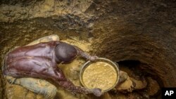 FILE - Miners extract mud at a gold mining site where adults and youth work in Uganda, Oct. 18, 2021. As the race to acquire economically vital minerals unfolds, those in Africa’s mining sector are calling to protect the women and children laborers who keep it running. 