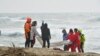 Des sauveteurs récupèrent un corps après le naufrage d'un bateau de migrants près de Cutro, dans le sud de l'Italie, dimanche 26 février 2023.