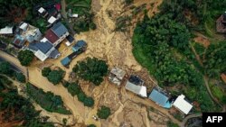 Sebuah mobil melaju melewati lokasi tanah longsor setelah badai di Longyan, provinsi Fujian, China timur, 17 Juni 2024. (CNS / AFP) 