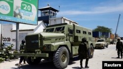 Des soldats de la paix de l'Union africaine se tiennent à côté d'un véhicule blindé de transport à Mogadiscio, en Somalie, le 27 avril 2022.