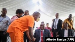 Ndambi Guebuza (à gauche), fils de l'ancien président du Mozambique Armando Guebuza, avec son père au début de la procédure judiciaire à la prison centrale de Maputo, le 30 novembre 2022.