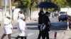 上海一家火葬场外身穿孝服的亲属手捧逝去亲人的遗像。（2022年12月23日）
