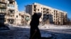 An elderly local resident walks past a destroyed residential building in Chasiv Yar, Eastern Ukraine, on Jan. 7, 2023, amid the Russian invasion of Ukraine. 