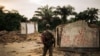 ARCHIVES - Un membre des forces armées congolaises se tient à côté d'un bâtiment incendié dans l'ouest de la République démocratique du Congo, le 1er février 2019.