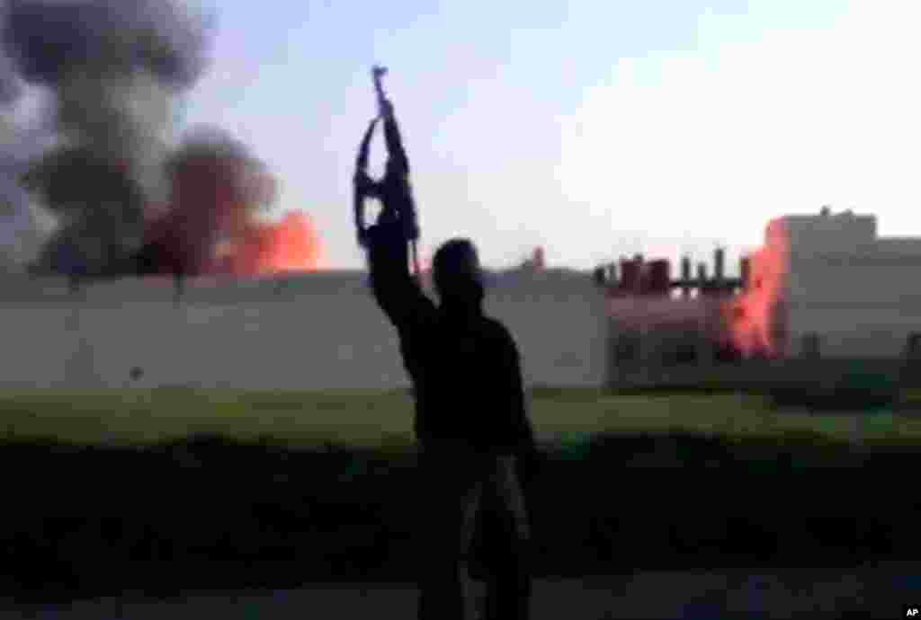 This image from video shows a building at the Syrian government checkpoint on fire in Dael, Syria, March 28, 2013. 