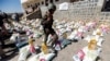 FILE - A Yemeni soldier, loyal to the Shi'ite Houthi movement, walks next to humanitarian aid supplies in a camp on the outskirts of the capital Sanaa, Yemen, March 16, 2017. 