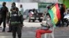 Foto de archivo de un oficial de policía hace guardia mientras un manifestante se sienta en la calle, en Santa Cruz, Bolivia, el 8 de noviembre de2021.