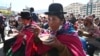 Una mujer indígena aymara tiene una porción del plato más grande de Bolivia, el chairo, una sopa tradicional del pueblo aymara a base principalmente de verduras y carne seca de cordero, plaza San Francisco de La Paz el 1 de julio de 2022.