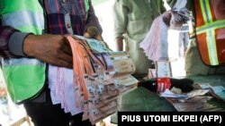 Un responsable électoral détient des bulletins de vote comptés dans un bureau de vote lors de l'élection du gouverneur à Ido Oshun, dans l'État d'Osun, dans le sud-ouest du Nigéria, le 16 juillet 2022.