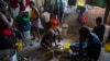 FILE - Seorang perempuan sedang memasak di penampungan keluarga yang mengungsi akibat kekerasan geng di Port-au-Prince, Haiti, 9 Desember 2021.