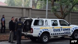 Des agents de la douane et de l'unité sud-africaine de confiscation d'actifs lors d'une perquisition au domaine de la famille Gupta, le 16 avril 2018 à Johannesburg. 