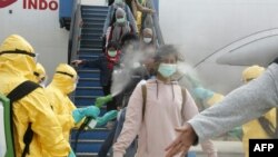 印尼官员为从武汉撤离的印尼留学生进行消毒。