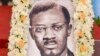Un portrait du héros de l'indépendance congolais tué Patrice Lumumba près du cercueil contenant son seul reste, une dent, au Palais du Peuple à Kinshasa le 27 juin 2022. (Photo Arsène Mpiana / AFP)