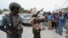Seorang polisi Kenya tampak mengambil foto warga Haiti di di Port-au-Prince, pada 3 Juli 2024. (Foto: AP/Odelyn Joseph)