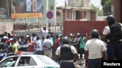 La Police nationale haïtienne surveille une zone commerciale qui a été pillée pendant les manifestations contre les hausses des prix du carburant à Port-au-Prince, Haïti, le 8 juillet 2018. REUTERS / Andres Martinez Casares 