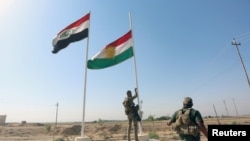 Un membre des forces de sécurité irakiennes descendant le drapeau kurde à Kirkouk, Irak, le 16 octobre 2017.