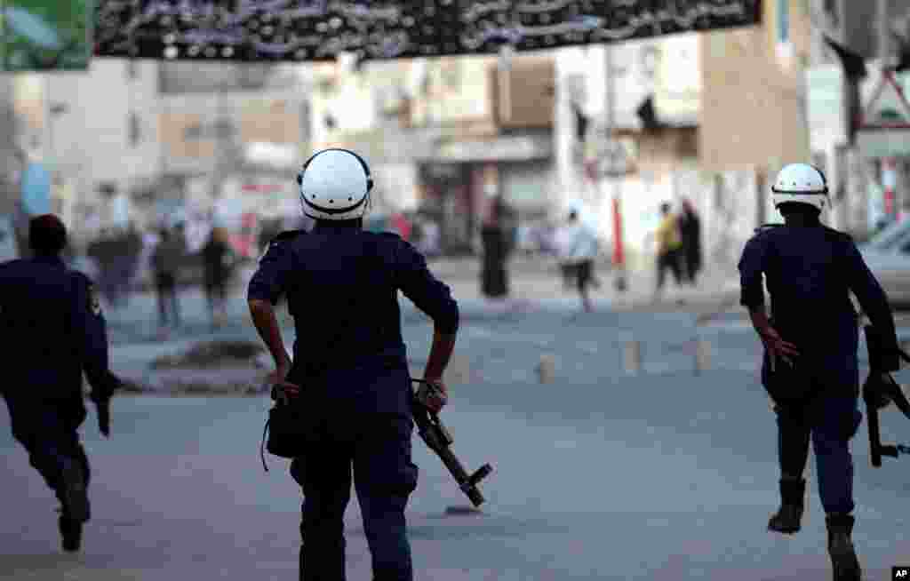 Riot police chase anti-government protesters during clashes in Malkiya village, Bahrain, January 7, 2013.