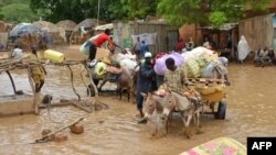 Des habitants portent leurs affaires alors qu'ils évacuent leurs habitations à Niamey, la capitale du Niger, le 19 août 2012. 