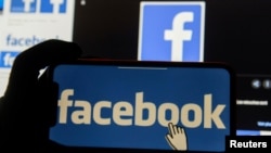 FILE - The Facebook logo is displayed on a mobile phone.