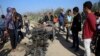 FILE - In this Monday, Nov. 12, 2018 file photo, Palestinians inspect a vehicle that was destroyed in an Israeli raid that killed seven Hamas Palestinian militants, including a local Hamas commander, late Sunday, east of Khan Younis, southern Gaza Strip.