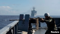 在菲美海軍在南中國海的海上演習中，一名菲律賓海軍士兵在軍艦上射擊，2014年6月29日(資料照片)