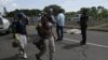 Un migrant tombé d'un véhicule est décédé alors que d'autres migrants marchent dans la banlieue de Tapachula, au Mexique, le 22 octobre 2018. 