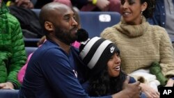 Kobe Bryant and his daughter Gianna watch the first half of an NCAA college basketball game between Connecticut and Houston, Saturday, March 2, 2019, in Storrs, Conn. (AP Photo/Jessica Hill)