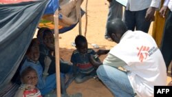 Un employé de MSF (Médecins sans frontières) examine des enfants souffrant de malnutrition dans un camp de réfugiés maliens situé à Chinegodar, dans l'ouest du Niger, près de la frontière malienne, le 4 février 2012.