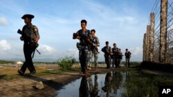 Cảnh sát Myanmar tuần tra dọc theo hàng rào sát biên giới Bangladesh ở Maungdaw, bang Rakhine, Myanmar, ngày 14 tháng 10, 2016. 