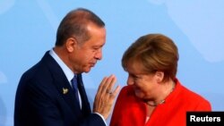 Le président turc Recep Tayyip Erdogan parle à la chancelière Angela Merkel à Hamburg, Allemagne, le 7 juillet 2017.