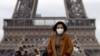 Une femme porte un masque de protection contre l'épidémie de coronavirus alors qu'elle marche sur l'esplanade du Trocadéro en face de la Tour Eiffel à Paris, France, le 1er février 2020. REUTERS / Gonzalo Fuentes - RC2ORE9D3SPA