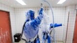 Doctor for tropical medicine Florian Steiner (L) cleans ward physician Thomas Klotzkowski in a disinfection chamber at the quarantine station for patients with infectious diseases at the Charite hospital in Berlin August 11, 2014. 