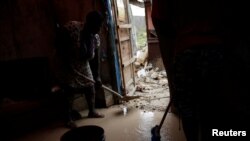 Des sinistrés tentent d'extirper la boue de leur maison endommagée après le passage de l'ouragan Matthew sur la ville de Jérémie, Haïti, 6 octobre 2016.