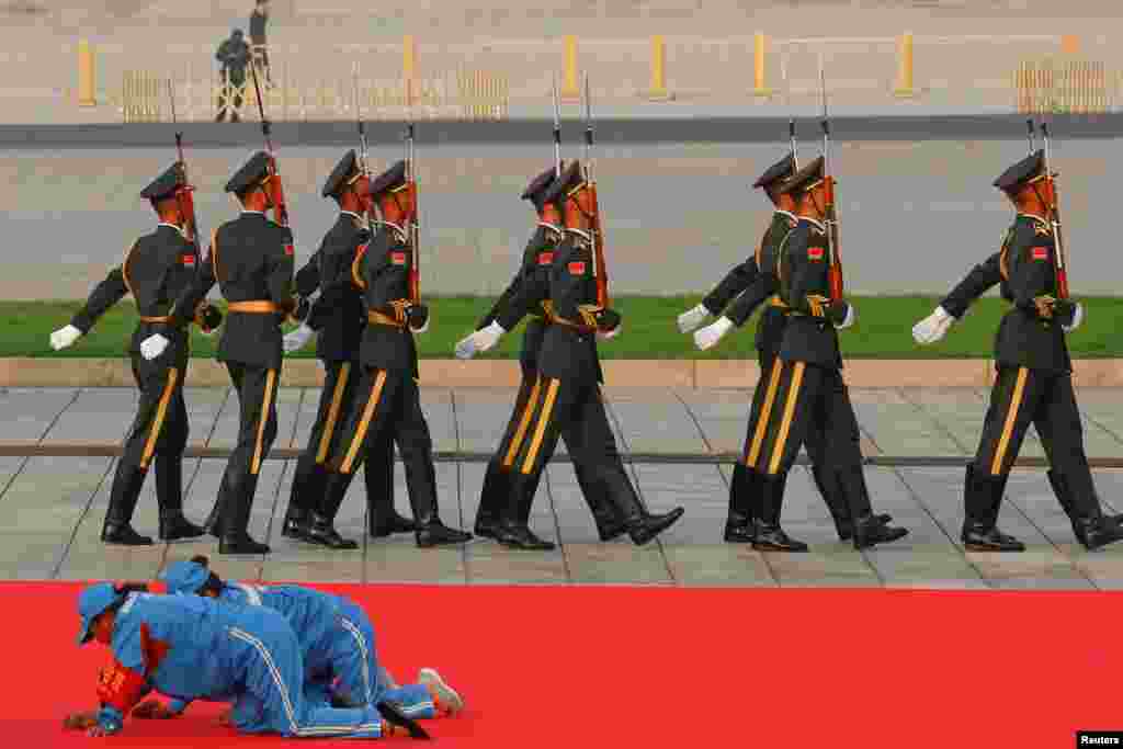 Workers clean a red carpet before a wreath-laying ceremony at the Monument to the People&#39;s Heroes in Tiananmen Square, marking the 70th anniversary of the founding of the People&#39;s Republic of China, in Beijing, China.
