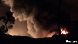 Fumées épaisses et flammes près de l'aéroport militaire de Mazzé, banlieue ouest de Damas, Syrie, le 13 janvier 2017. 