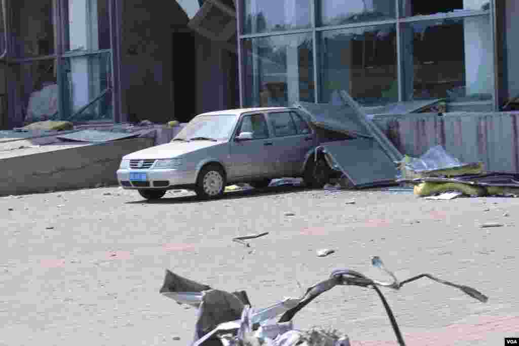 天津爆炸事故現場，核心爆炸區週圍多座居民樓窗戶被震碎，高速公路橋樑受損，多輛大貨車被炸翻，小汽車起火或被砸，多名當地居民仍逗留在事故現場。（美國之音記者東方拍攝）