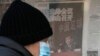FILE - A man looks at a kiosk displaying a newspaper with a photo of Chen Xuyuan, head of the Chinese Football Association, in Beijing, Feb. 15, 2023. 