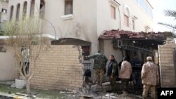 Les forces de sécurité libyennes fouillent le lieu où une bombe a explosé près de la résidence de l’ambassadeur iranien à Tripoli, 22 février 2015.
