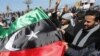 Anti-Libyan leader Moammar Gadhafi protesters wave the old Libyan flag as they celebrate the freedom of the Libyan city of Benghazi, February 28, 2011