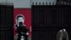 在上海，习近平画像前带口罩的人（2020年2月10日）