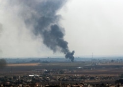 In this photo taken from the Turkish side of the border between Turkey and Syria, in Ceylanpinar, Sanliurfa province, southeastern Turkey, smoke billows from a fire in Ras al-Ayn, Syria, Oct. 20, 2019.