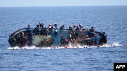Cette image fournie par la marine italienne montre le naufrage d'une embarcation surpeuplée de migrants au large des côtes libyennes, mercredi 25 mai 2016.