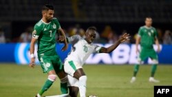 Riyad Mahrez, à gauche, en lutte avec Sadio Mane lors du match de poule de la CAN 2019 entre le Sénégal et l'Algérie, Caire, le 27 juin 2019
